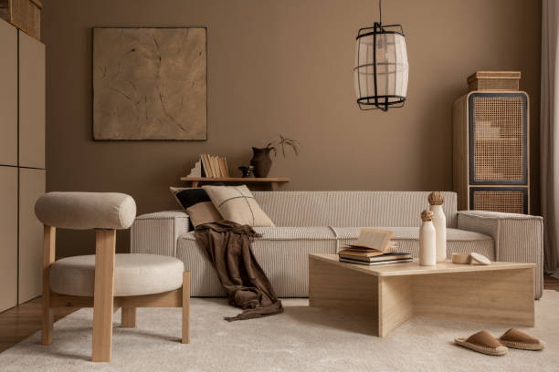 istock Elegant composition of warm living room interior with mock up poster frame, modular sofa, travertine coffee table, gray armchair, rattan sideboard, lamp and personal accessories. Home decor. Template. 1816652651