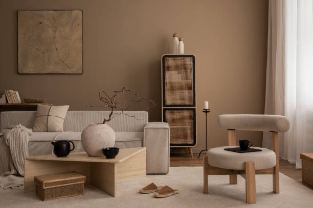 istock Elegant composition of warm living room interior with mock up poster frame, modular sofa, travertine coffee table, gray armchair, rattan sideboard, lamp and personal accessories. Home decor. Template. 1816653232