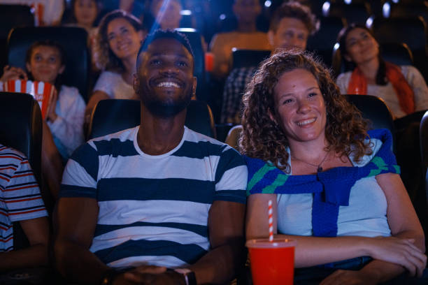 istock Diverse couple sitting inside movie theater 1816659903