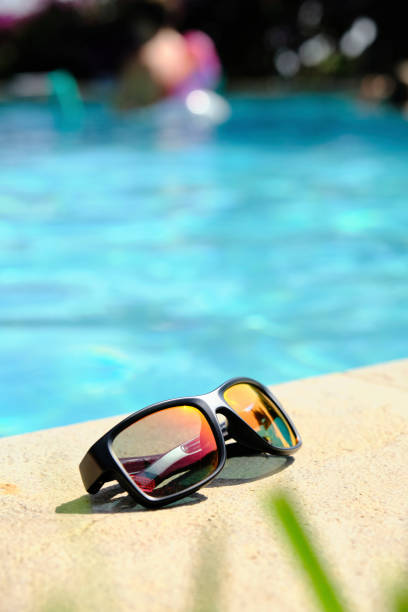 istock sunglasses on the background of the pool 1816663815