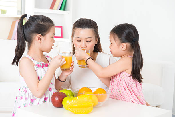 istock Asian parent and children drinking orange juice 181666709