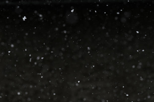 istock Bokeh of white snow on a black background. Snowfall - design element. 1816671404