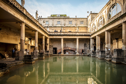 The Roman Baths, situated in the heart of the historic city of Bath, UK, transport visitors back in time to the height of Roman civilization. This exceptionally preserved archaeological site showcases the ancient bathing and socializing complex that dates back to the Roman period. The Great Bath, with its intricate lead lining and original Roman pillars, takes center stage, surrounded by well-preserved rooms, corridors, and alcoves that once constituted a thriving social hub. The site also features the fascinating Temple Courtyard and the Sacred Spring, the source of the baths' thermal waters. The Roman Baths offer a multi-sensory experience, combining informative exhibits with the chance to stroll through atmospheric chambers. As visitors wander among the ancient columns and steamy pools, the immersive nature of the site provides a vivid glimpse into the daily lives and rituals of the Romans. The adjacent Pump Room and the elegant Georgian architecture of the surrounding city further enhance the overall historical charm of this UNESCO World Heritage Site.