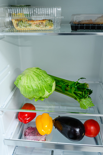 Fresh Vegetables lying on the shelf in the fridge. Fresh vegetable storage concept.