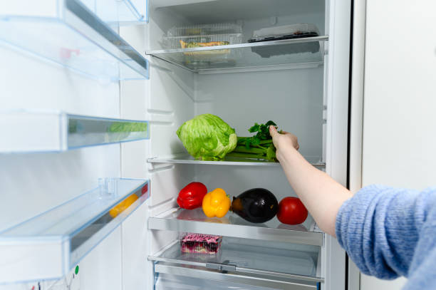 istock A woman puts celery in the refrigerator. 1816684502
