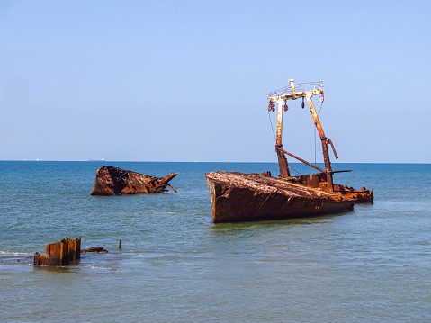 Rusty old abandoned iron fishing boat which is pulled out on the coast of the sea in Teriberka