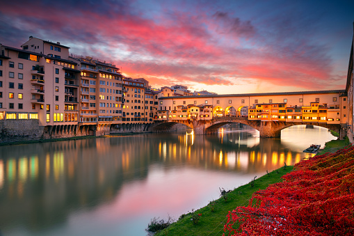 Cityscape image of iconic Florence, Italy with famous Ponte Vecchio (Old Bridge) at beautiful autumn sunset.
