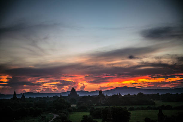 The sunset in Bagan is a spellbinding spectacle that enchants visitors with its ethereal beauty. As the sun begins its descent over the ancient temples and pagodas scattered across the plains, the landscape transforms into a golden tapestry of warm hues. The silhouettes of the historic structures create a dramatic backdrop against the vivid colors of the sky, ranging from fiery oranges to soft purples. As the sun dips below the horizon, the temples cast long shadows, and the entire scene is reflected in the tranquil waters of the Irrawaddy River. The sunset in Bagan is a magical moment, inviting contemplation and providing a sense of timelessness in this ancient and spiritually rich landscape.