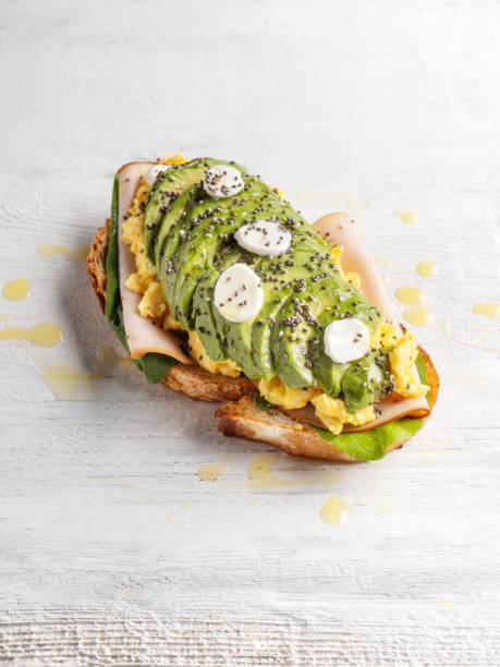 istock Avocado bread. Tapas. Sandwich with egg and avocado. Avocado with ham and scramble egg on rye bread. 1816706055