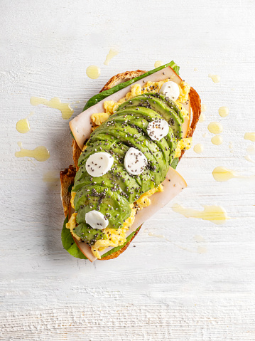 toast with avocado, spinach and fried egg, top view