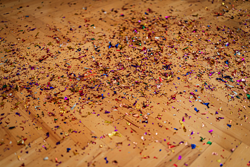 Wooden floor covered with confetti after party
