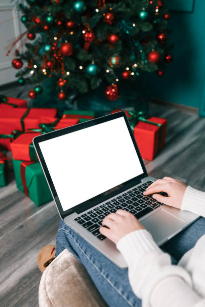 istock Young woman work on laptop computer with blank display screen with mockup copy space. Modern home living room interior design. Christmas, New Year decorated workspace 1816716205