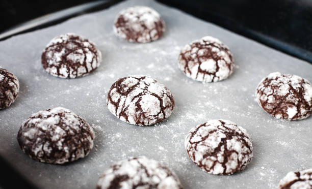 istock Chocolate cookies with powdered sugar on baking tray. Close-up. 1816716217