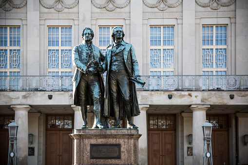 Weimar, Germany - December 23, 2014: The Statues of Goethe and Schiller Located in Weimar.

The statues of Johann Wolfgang von Goethe and Friedrich Schiller, located in Weimar, Germany, are iconic monuments paying tribute to two of the country's most renowned literary figures. Positioned in front of the German National Theatre in Theaterplatz, the statues symbolize the enduring friendship and intellectual collaboration between Goethe and Schiller, who were pivotal figures in German literature during the Classical and Weimar Classicism periods.

The statues were unveiled in 1857 and sculpted by Ernst Rietschel. The monument features Goethe and Schiller in animated conversation, embodying the spirit of intellectual exchange and artistic collaboration that defined their relationship. The site has become a symbol of Weimar's cultural heritage, attracting visitors and literature enthusiasts from around the world. It stands as a fitting tribute to the profound impact Goethe and Schiller had on German literature and intellectual thought during a pivotal era in the country's cultural history.