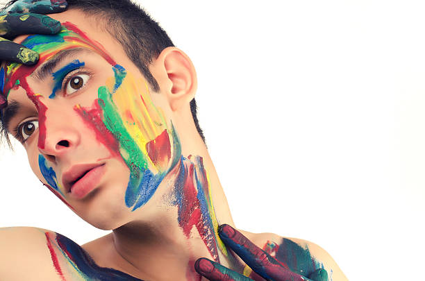 istock Beautiful young man painted on the face with many colours 181672244