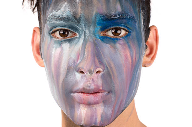 istock Beautiful young man painted on the face with many colours 181672250