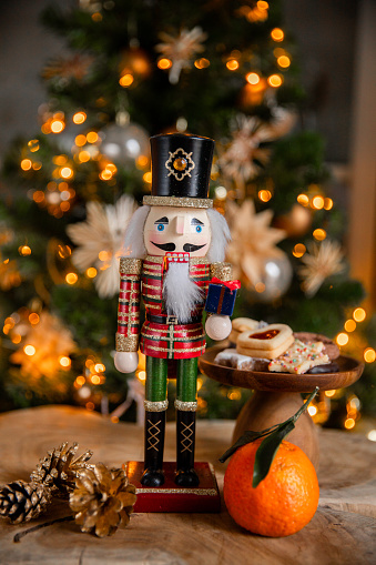 A classic nutcracker in front of a Christmas tree