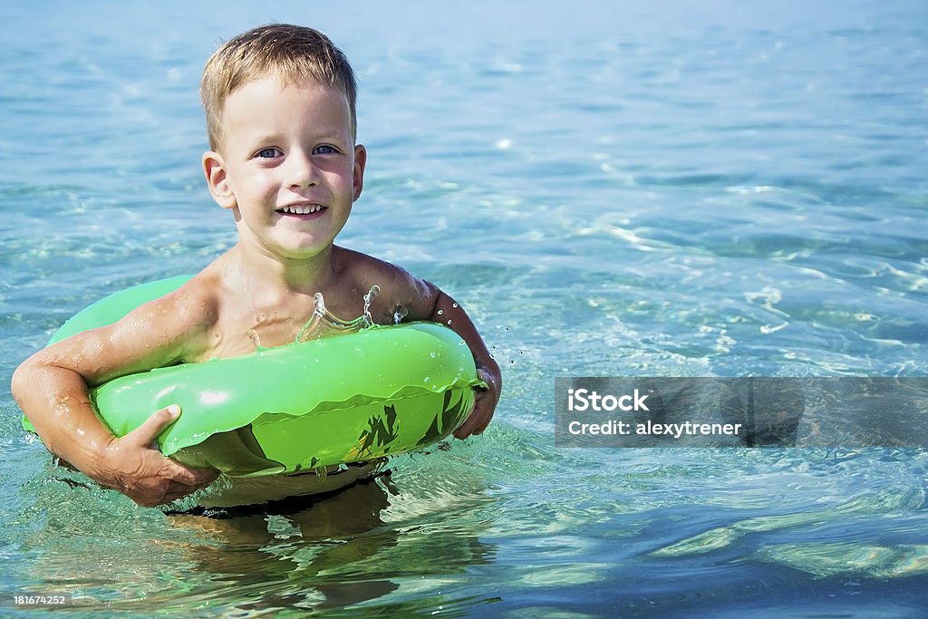Menino feliz está a nadar no mar com anel de Borracha - Royalty-free Alegria Foto de stock