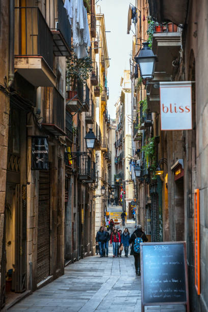 Barcelona, Spain - January 22, 2015: The Gothic Quarter (Barri Gòtic). \n\nWander through narrow medieval streets lined with centuries-old buildings, discovering hidden squares and Gothic landmarks like the Barcelona Cathedral. This atmospheric neighborhood combines Roman and medieval architecture, offering a captivating journey through time. Enjoy the vibrant street life, tapas bars, and the enchanting ambiance of one of Europe's most captivating old quarters.