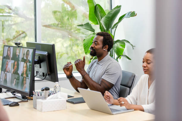 istock Businessman leads virtual meeting while female co-worker uses laptop 1816744453