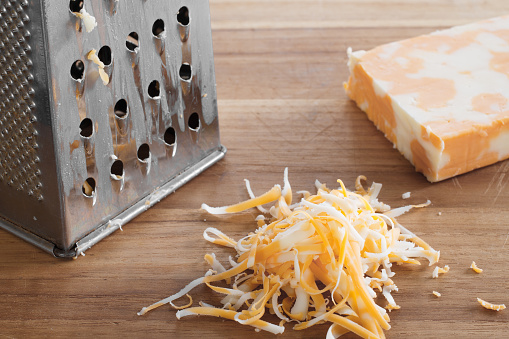 Grated marble cheese on cutting board