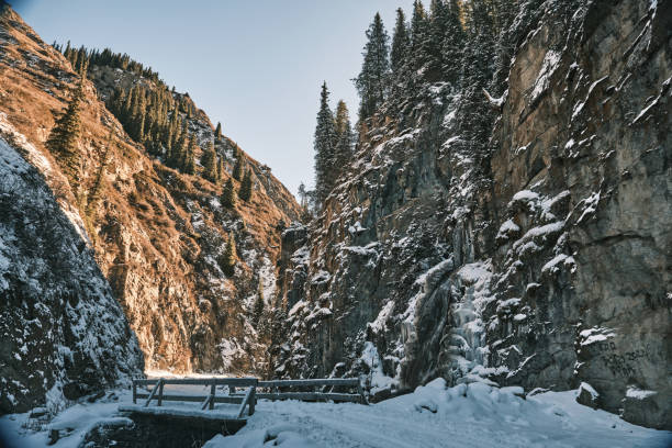 Frozen waterfall above bridge in winter mountain gorge