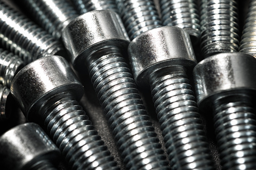 Close up of round-headed metal screws on a table