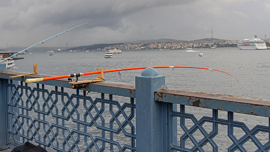 Fluorescent Orange Fishing Rod in Wooden Holder at Bridge Istanbul Turkey