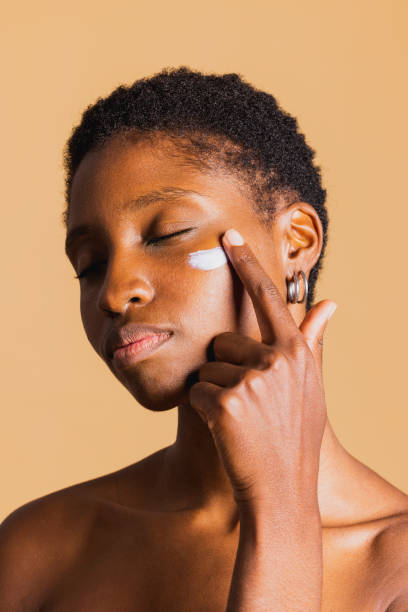 istock Young woman applying cream on her face. 1816832264
