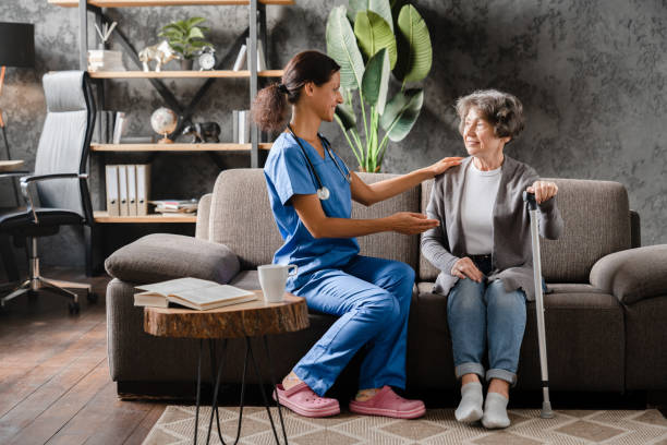 istock Dialogue between elderly senior grandmother patient with motion problems disability and mature caregiver. Hospice treatment. Visiting grandmother in private hospital 1816833819