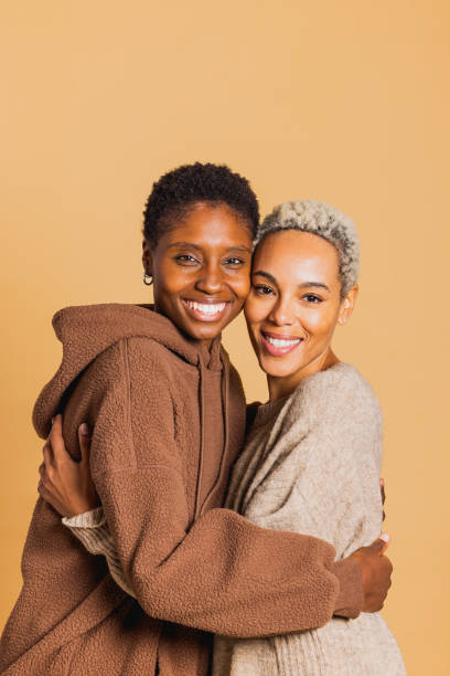 istock Two young women embracing on brown background 1816834133