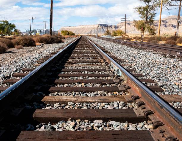 istock Low angle view of railroad tracks leading to a vanishing point. 1816856884