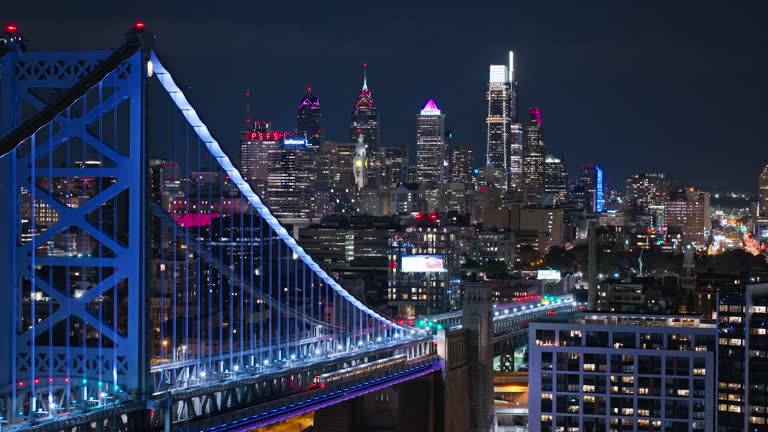 Drone Flight Along Train Traveling on Benjamin Franklin Bridge in Philadelphia at Night