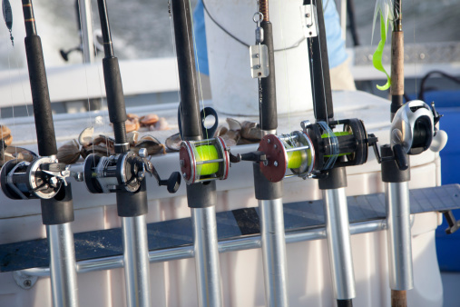 Fishing rods and bait laying on a table on a charter boat driving out to sea on a sunny day