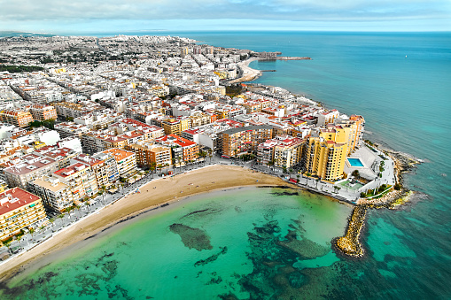 Drone point of view sandy beach, coastline of Playa del Cura in spanish resort Torrevieja city at summertime. Costa Blanca. Spain. Travel and tourism concept