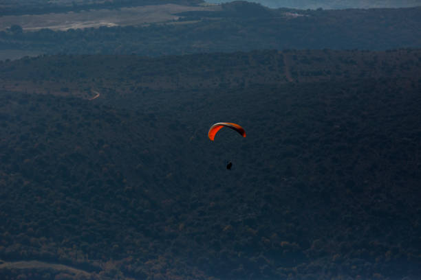 A paragliding pilot flying in the air, thermals, cross country