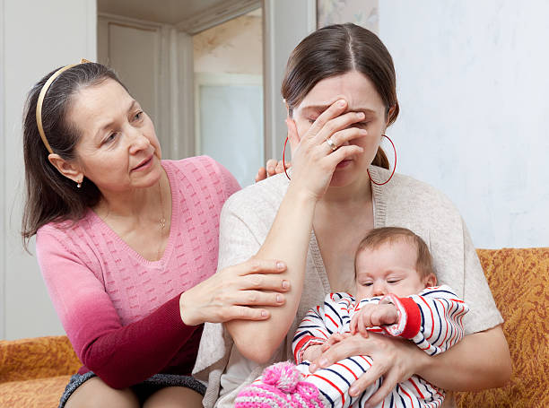 istock Mature woman comforts crying daughter with baby 181693763