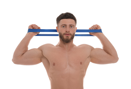 Young man exercising with elastic resistance band on white background