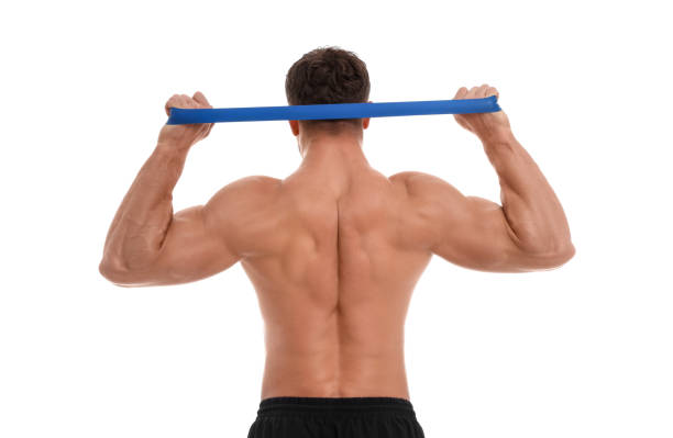 istock Young man exercising with elastic resistance band on white background, back view 1816953466