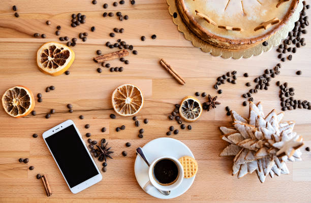 istock Coffee in a cup on a table with christmas decoration and smartphone. Overhead view. 1816961772