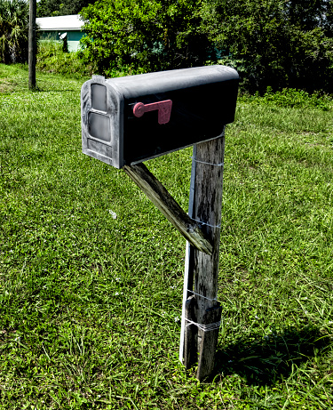 Close up one residential black mailbox on green grass in Florida