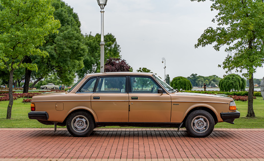 Classic Volvo 200 series (244 GL) in bronze gold yellow metallic color. Side view.  02.07.2023 Palic, Serbia