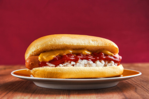 Hot dog in a bread bun with tomato ketchup and mustard