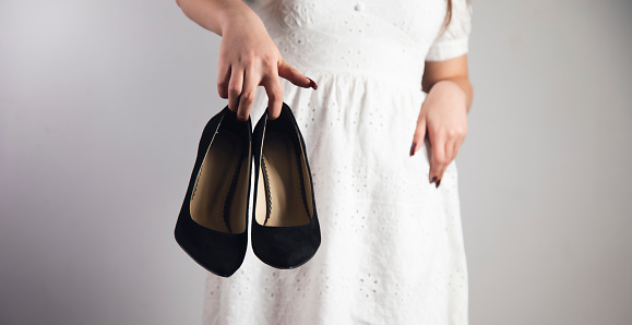 young girl holding shoes in her hands