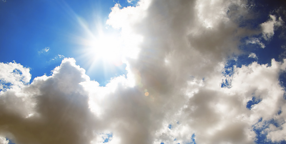 Empty Blue sky with gorgeous clouds and sun shining through