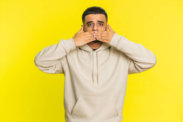 istock Frightened Indian man closing mouth with hands refusing to tell terrible secret, unbelievable truth 1816994341