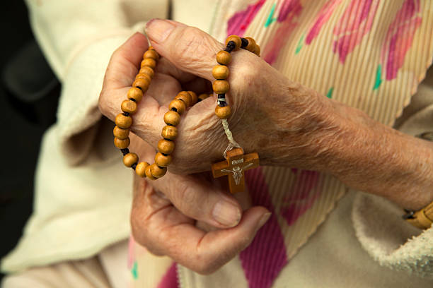 istock Old woman prays the rosary 181699497
