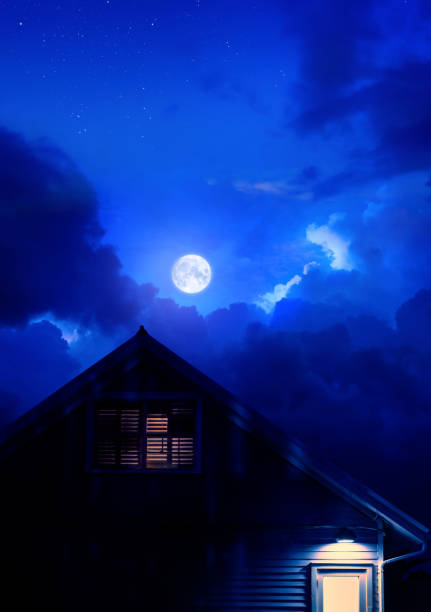 A mysterious house with soft lights on during full moon in dusk in dark blue sky in Key West,Florida