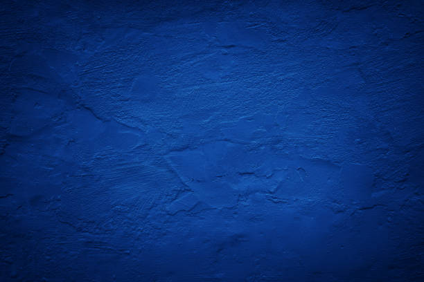 istock Black dark blue painted concrete wall. Toned grunge background. Rough grainy plaster texture surface.  Cobalt color. Exterior. Close-up. 1817001997