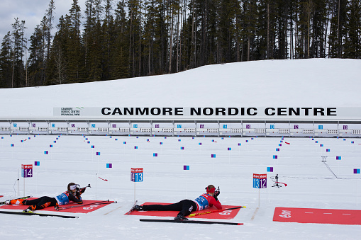 Two female athletes take part in shooting practice at the biathlon shooting range at the Canmore Nordic Centre Provincial Park in Alberta, Canada, during the Biathlon World Cup on February 2, 2016. (John Gibson Photo/Gibson Pictures)